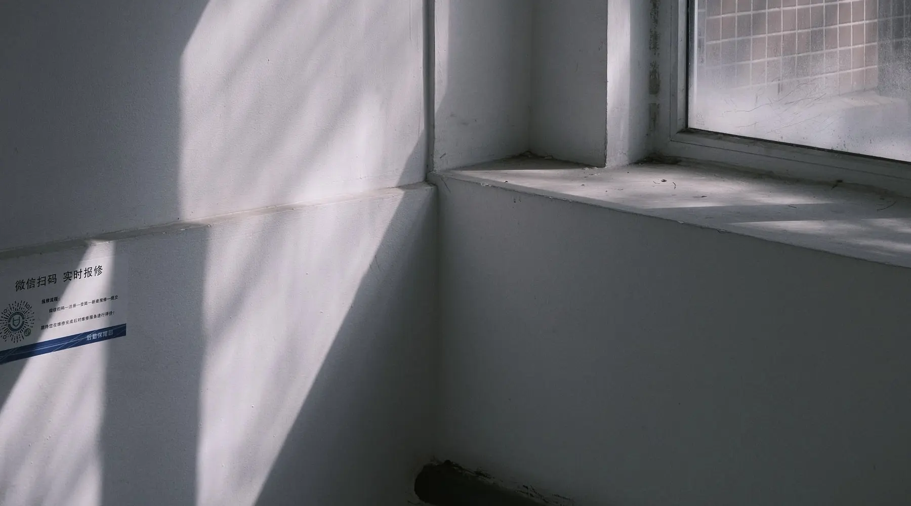 Daylight falling across a plain white wall in the clinic.
