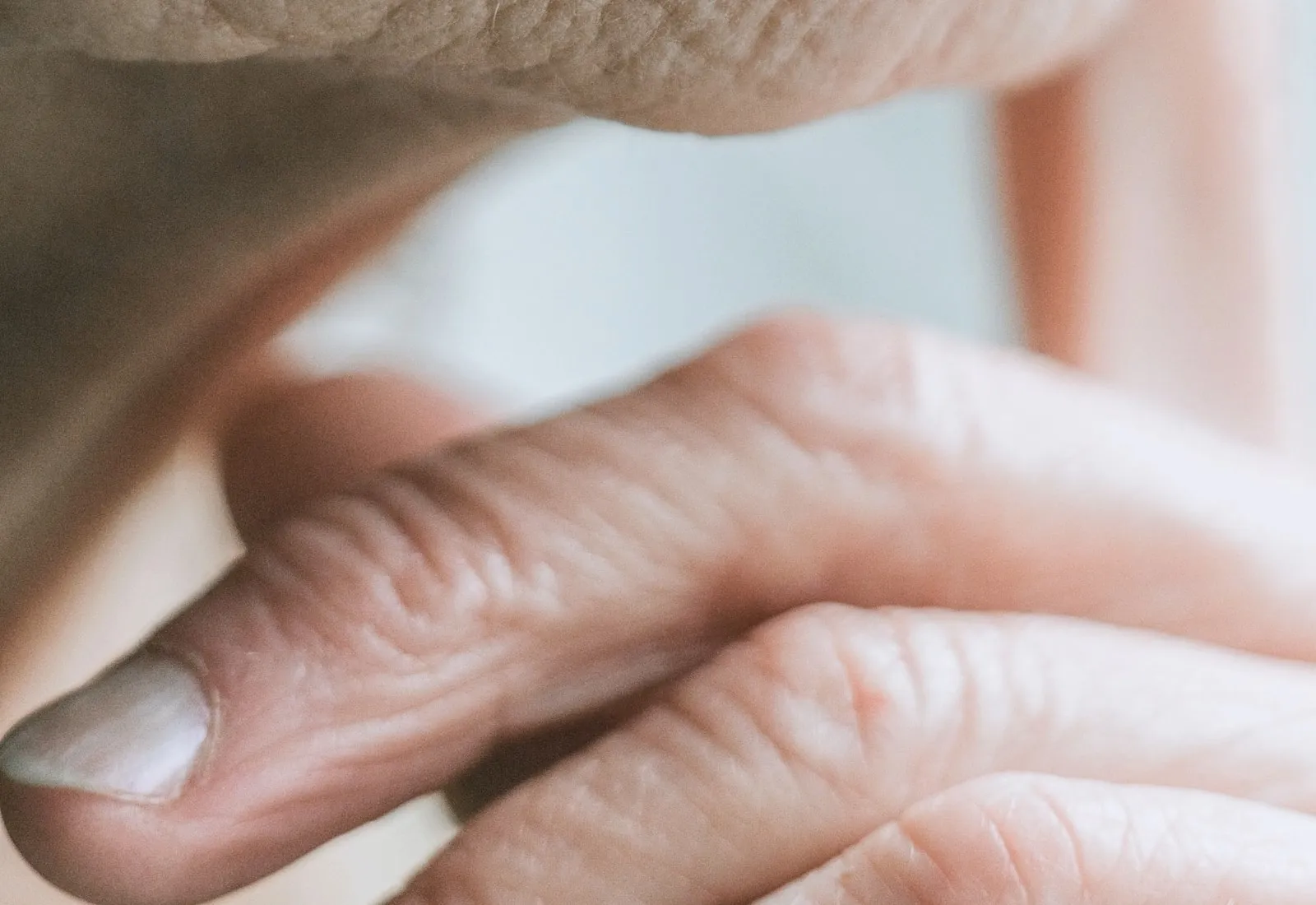 A hand resting against a cheek in soft light.